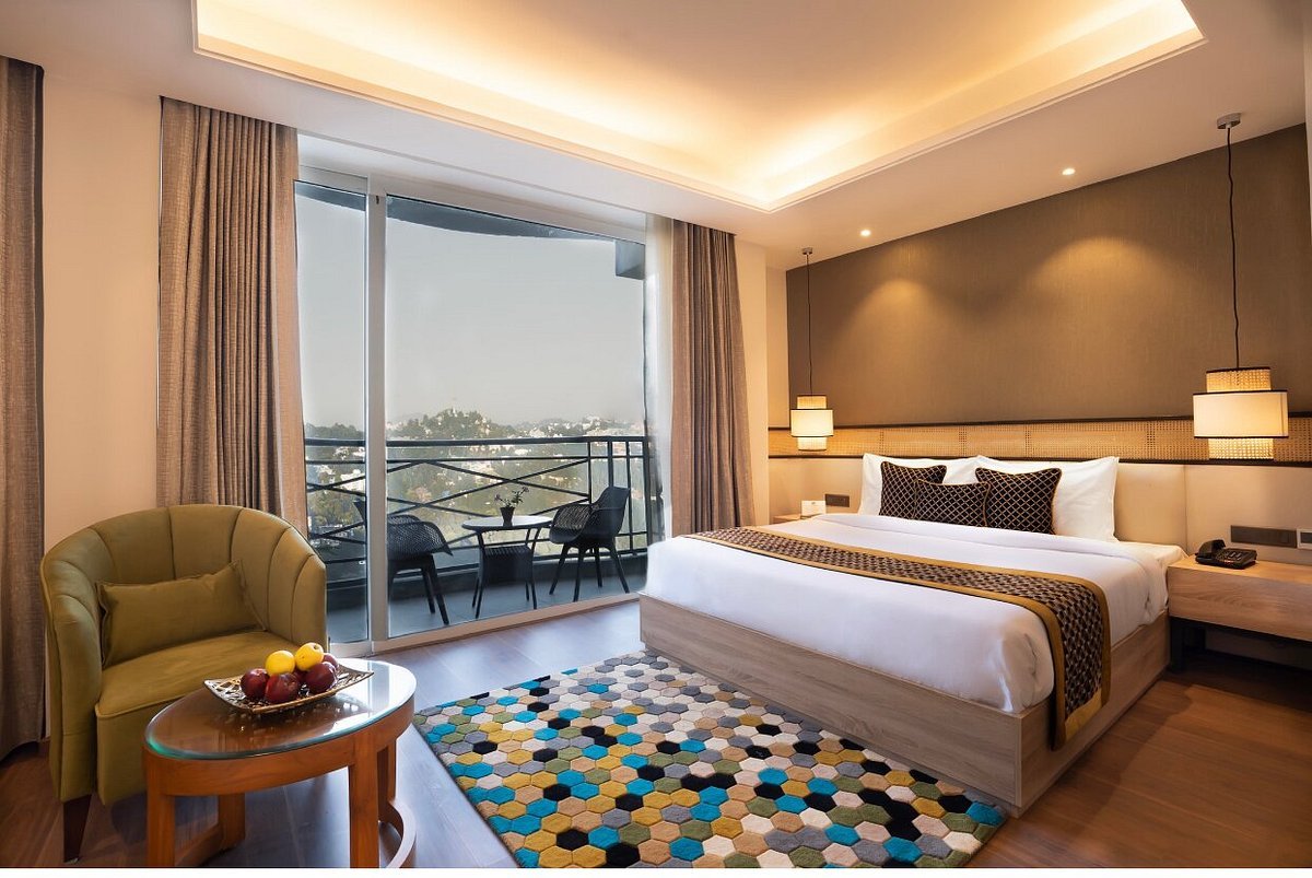 A neon hotel sign against a cloudy sky.